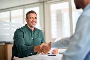hr manager and new worker shake hands recruiting at job interview