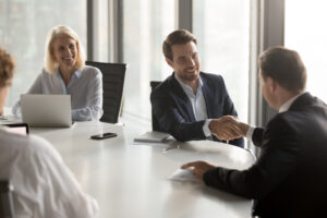 Happy business partners shaking hands expressing respect, closing banking investment corporate deal