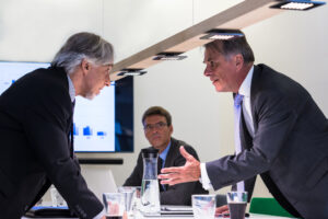 Conflict in office  Business executive arguing with his boss at meeting over latest sales figures with others watching